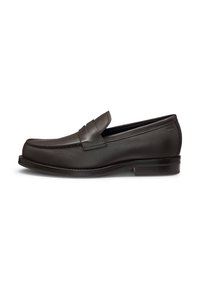 Mocasín de cuero marrón con una textura suave, punta redondeada, detalles de costura y un tacón bajo. Diseño sin cordones con un acento de tira en la parte frontal.