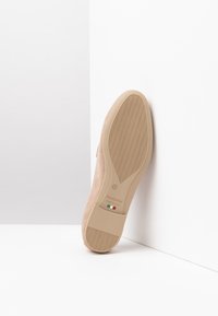 NeroGiardini beige suède schoen met een gestructureurde rubberen zool, voorzien van een klein Italiaans vlaglogo en maat "37" gedrukt op de onderkant.