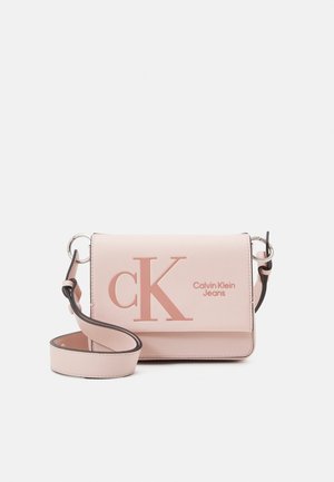Jasnoróżowa torebka na ramię Calvin Klein Jeans z regulowanym paskiem i dużym wytłaczanym logo "cK" na przedniej klapie.