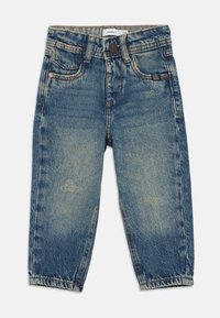 Jean en denim bleu avec une coupe décontractée, présentant des zones décolorées, un design à cinq poches et un détail de couture marron autour de la taille.