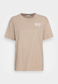 Beige tričko s krátkým rukávem a kulatým výstřihem s malým bílým textem na levé části hrudníku, který zní "Marc O'Polo Denim Academy Organic Club".