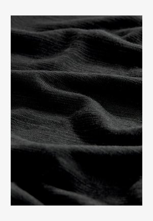 Fekete szövet, puha, texturált felülettel, amely finom hullámokat és redőket mutat, jelezve, hogy könnyű és rugalmas anyagról van szó.