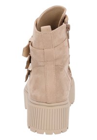 Beige ankboot i mocka, med en kraftig sula, bakre dragkedja och remmar på sidan. Strukturerad yta och robust design.