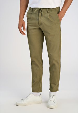 Olive green chinos with a drawstring waist, featuring two side pockets, a smooth texture, and tapered fit, paired with white sneakers.