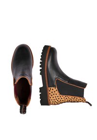 Schwarze Leder-Stiefeletten mit braunem Akzent, einer beigen Seite mit Herzmuster und einer klobigen schwarzen Sohle mit Rillen.