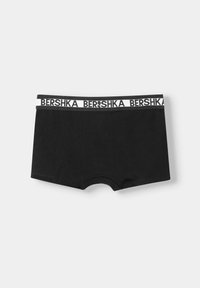 Črne bokserice iz mehkega materiala z belim pasom, na katerem je v kontrastnem slogu natisnjeno ime blagovne znamke "Bershka".