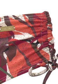 Haut de bikini multicolore avec un motif floral dans des teintes de rouge, de vert et de blanc, doté de détails froncés et d'une étiquette avec logo doré.