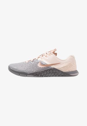 Chaussures de sport légères avec une tige en mesh gris, des accents rose pâle et une semelle extérieure en caoutchouc noir texturé présentant un motif unique.