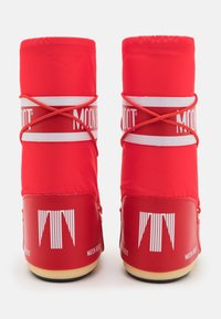 Pair of red Moon Boot winter boots with white logo bands and crisscross laces viewed from the back on a white background.