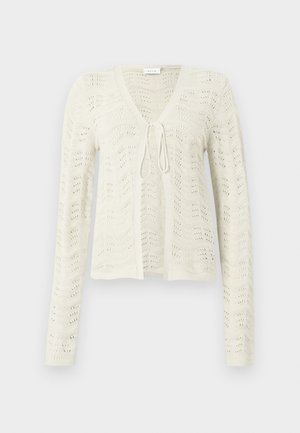 Cardigan en tricot ivoire avec un col en V et des manches longues, présentant un motif texturé en forme de vague et un détail noué à l'avant.