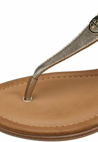 Sandală de tip flip-flop din piele maro, cu o curea metalică argintie și textură netedă. Post deget rotund cu un accent din nit metalic.