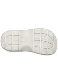 Suela de zapato de goma blanca con un patrón texturizado, que presenta agarres rectangulares y circulares, y una marca moldeada en el centro.