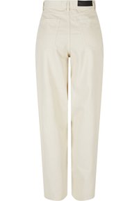 Pantalon en velours côtelé écru taille haute, jambes droites et deux poches arrière, vu de dos.