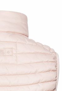 Effen roze vest met een hoge kraag, horizontale gewatteerde textuur en een ritsluiting aan de rechterkant. Heeft een klein logo label.