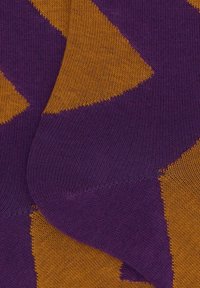 Calze con un motivo geometrico viola e arancione, caratterizzate da una morbida trama a maglia con colori a blocchi contrastanti e bordi lisci.
