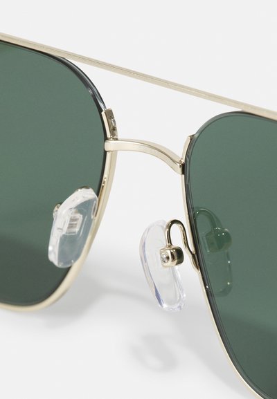 Gullmetall aviator solbriller med mørkegrønne linser, med justerbare klare nesepadder og et stilrent minimalistisk design.