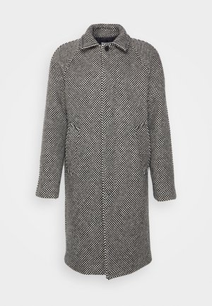 Lang uldfrakke med sort-hvid ternet mønster, knaplukning foran, sidelommer og klassisk krave.