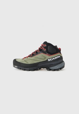 Scarpa verde e nera di altezza media per escursionismo con lacci rossi, suola robusta, etichetta Gore-Tex e logo SCARPA sul lato.