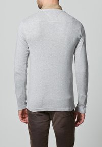 Szara koszula z długim rękawem wykonana z miękkiej bawełny, charakteryzująca się prostym designem z okrągłym dekoltem i kontrastującym kołnierzykiem. Gładka tekstura, casualowy krój.