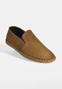 Slip-On-Schuh aus braunem, durchlöchertem Leder mit spitzem Zehenbereich und kontrastierender, leichtem Gummisohle, die am Rand ein gewebtes Design aufweist.