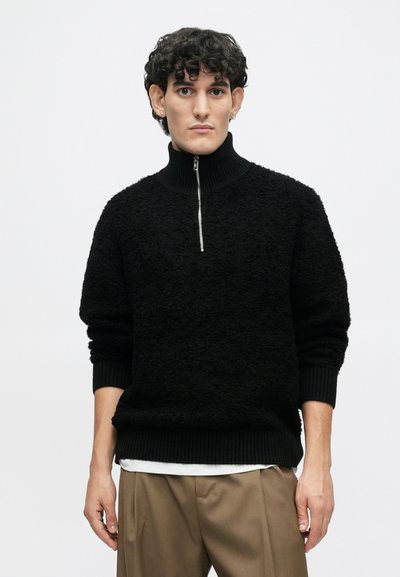 Schwarzer Fleece-Pullover mit einem hohen gerippten Kragen und einem halben Reißverschluss an der Vorderseite, mit einer strukturierten Oberfläche sowie gerippten Bündchen und Saum.