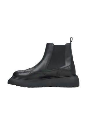 Black leather Chelsea boots with elastic sides, brogue detailing, and a chunky rubber sole. Smooth texture with a pull tab for easy wear.
