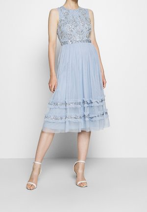 Jasnoniebieska sukienka bez rękawów z koralikowym stanem, zwiewną spódnicą z falbankami oraz cekinowymi zdobieniami wzdłuż brzegu.