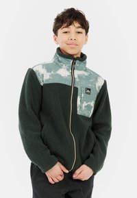 Fleece jack met een groene structuur body, lichtblauwe en witte gedessineerde bovenkant, ritssluiting aan de voorkant, en een borstzak met een logo.