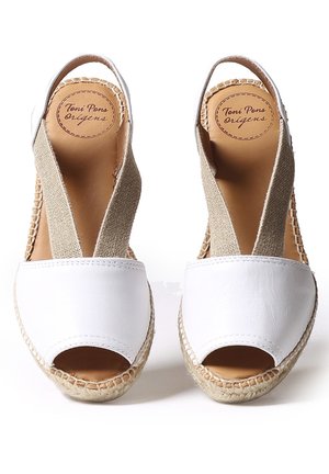 Chaussures espadrilles en cuir blanc avec bouts ouverts, brides élastiques beiges et semelles en jute tressé. Logo visible sur la doublure intérieure.