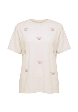 Beige kortærmet t-shirt med syv lyserøde hjerteformede applikationer jævnt fordelt på forsiden. Ingen synligt branding eller mønstre.