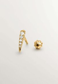 Pendientes de oro con un diseño puntiagudo y cinco piedras claras engastadas a lo largo de un borde, y un componente trasero en forma de flor.