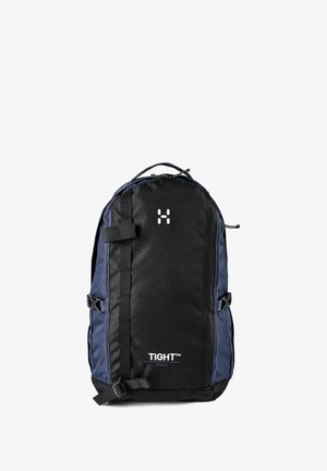 Sac à dos noir et bleu marine avec des sangles frontales, une poignée supérieure et le logo "TIGHT Medium" sur le panneau avant.