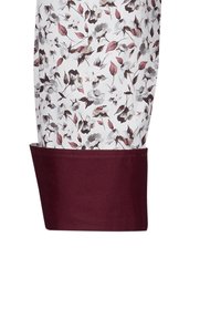 Manica di camicia con motivo floreale bianco, che presenta tonalità di bordeaux e grigio, con un polsino bordeaux uniforme. Materiale in cotone, texture liscia.
