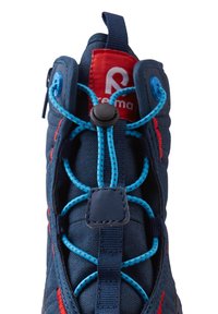 Zapatilla deportiva azul marino con acentos rojos, parte superior de tejido texturizado y cordones elásticos. Cuenta con un cierre de toggle para un ajuste seguro.