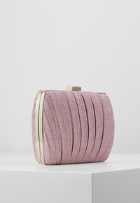 Rosa glittrig kuvertväska med veckad textur, metallackcenter i guldton och rektangulär form. Har ett lås framme på toppen.