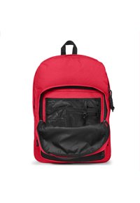 Mochila roja con una superficie texturada, que cuenta con un gran bolsillo frontal, compartimentos de malla en el interior y una sección inferior negra.