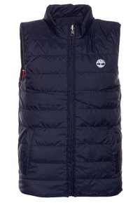 Námořnická modrá prošívaná vesta s vysokým límcem, zipem vpředu a bočními kapsami. Na hrudi má bílou logo a prošívanou strukturu.