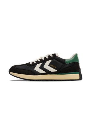 Black and green athletic shoes featuring a mesh upper, suede accents, and white chevron stripes. Cream midsole with textured black outsole.