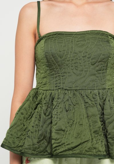Green quilted top with spaghetti straps, featuring a textured pattern, gathered peplum hem, and a smooth finish.