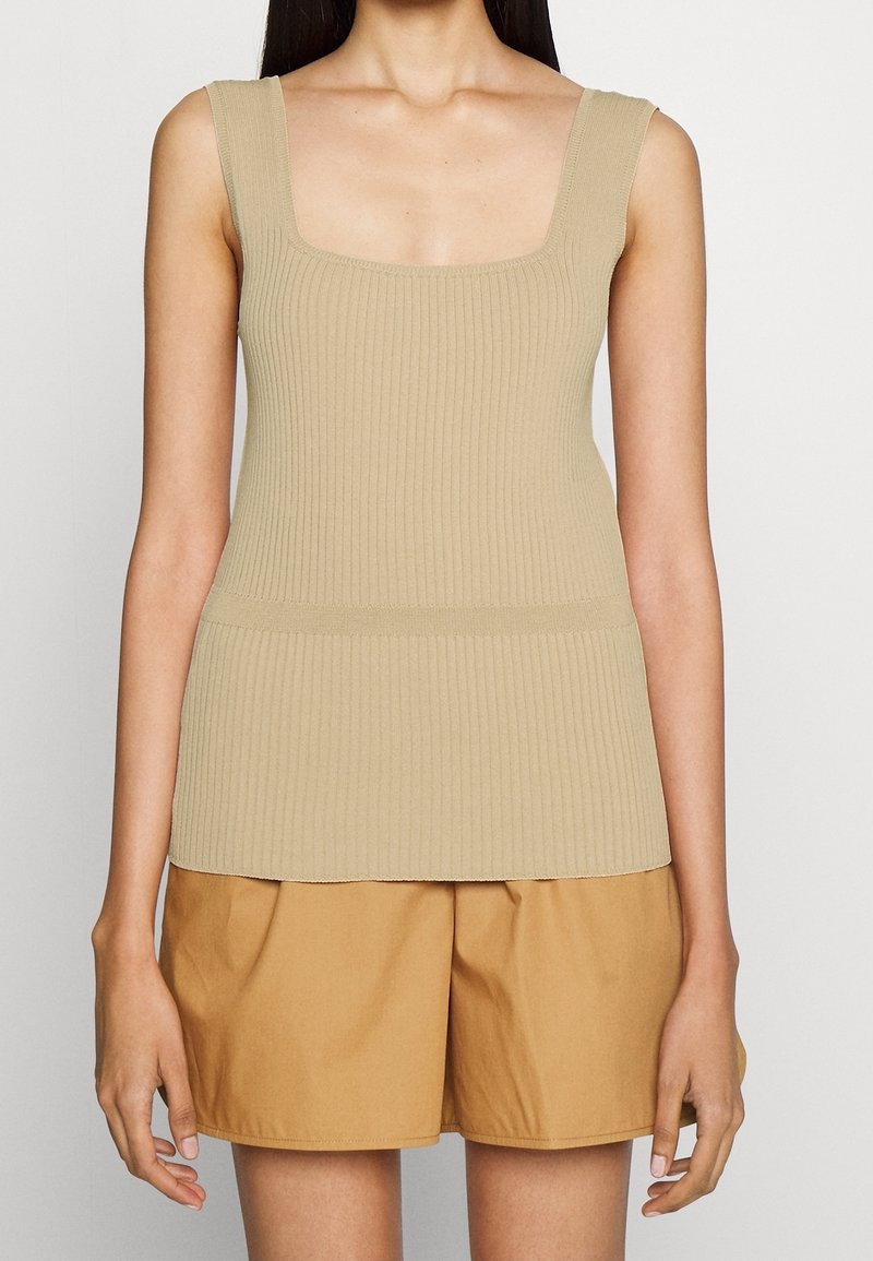 Beige gestreifter Tanktop mit quadratischem Ausschnitt und breiten Trägern, kombiniert mit hochgeschnittenen khakifarbenen Shorts. Glatte Textur, eng anliegendes Design.