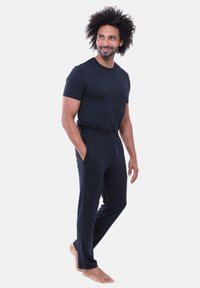 Granatowy t-shirt z kieszonką oraz spodnie o luźnym kroju wykonane z miękkiego materiału. Strój posiada elastyczną talię i gładką teksturę.