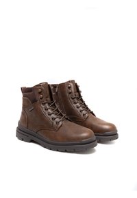 Brązowe skórzane botki za kostkę z wiązanym zapięciem, miękkim kołnierzem, gładką teksturą i solidną gumową podeszwą zapewniającą trwałość. Ozdobione metalowymi akcentami.