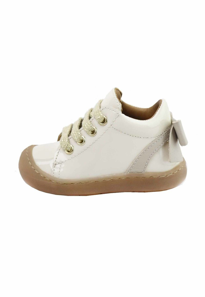 Zapato de charol blanco con punta redonda, ojetes dorados, cordones de beige texturizado y suela de goma beige; presenta un pequeño lazo en el talón.