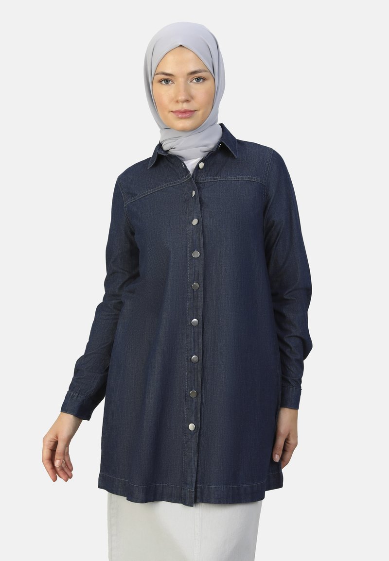 Donkerblauwe denim kraag jurk met een knoopsluiting aan de voorkant, kraag en omgeslagen mouwen. Heeft een recht model en lichte stikdetails.