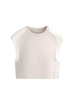 Brezrokavna in svetlo bež kratka majica s kontrastnimi belimi rameni in nežnimi navpičnimi detajli šivov na belem ozadju.