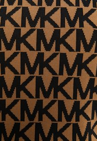 Tejido de punto con un patrón repetido de las iniciales negras "MK" sobre un fondo beige, con un acabado texturizado y suave.
