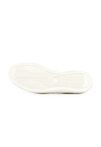 Suola di scarpa in gomma bianca con motivo a zigzag, caratterizzata da un emblema circolare e un bordo liscio. Design pulito e dettagli di texture minimi.