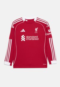 Crvena dugorukava nogometna majica s bijelim trakama, okruglog izreza, s logotipom Liverpool FC i logotipima sponzora na prednjem dijelu i rukavu.