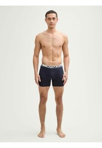 Boxers bleus navy avec une large ceinture de marque en gris. Fabriqués dans un tissu doux, ils présentent un design ajusté et une longueur mi-cuisse.