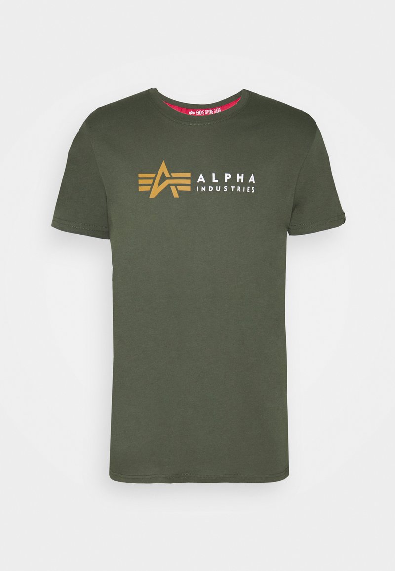Alyvuogių spalvos medvilninė marškinė, su baltu ir auksiniu "ALPHA INDUSTRIES" logotipu bei paprastu apykaklės dizainu. Trumpomis rankovėmis.